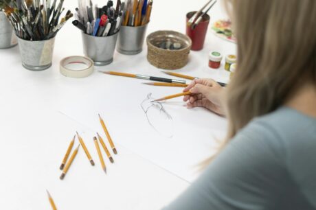 a young female artist drawing cartoon on a paper with pencil